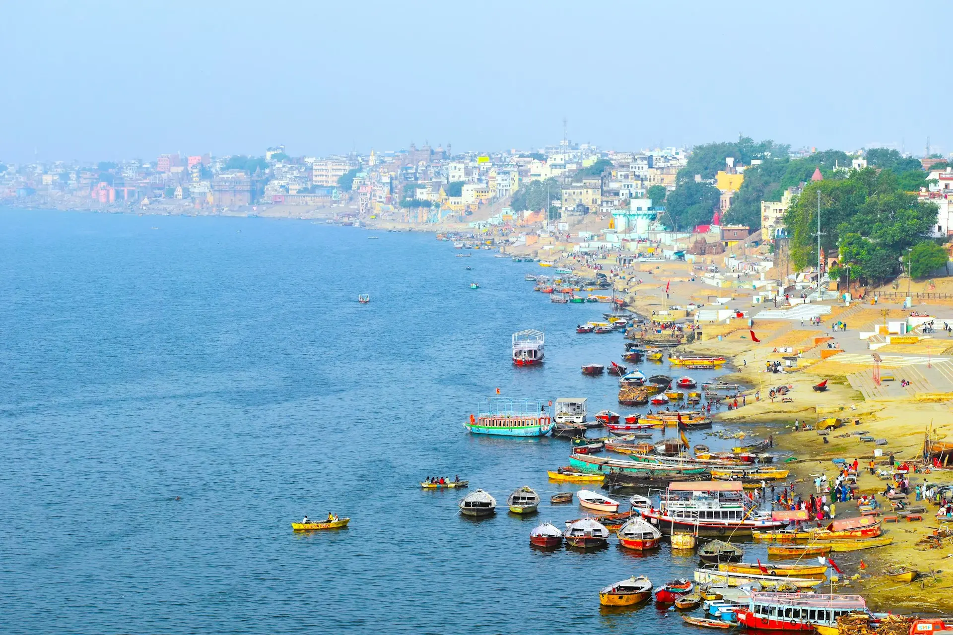 a beach with many boats and people